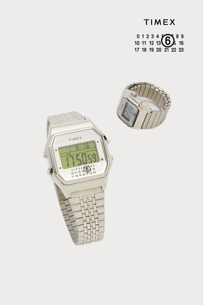 Silberne Digitaluhr mit rechteckigem Ziffernblatt, die die Uhrzeit und das Datum anzeigt. Verfügt über ein Metallband und einen Kalender auf dem Bildschirm.