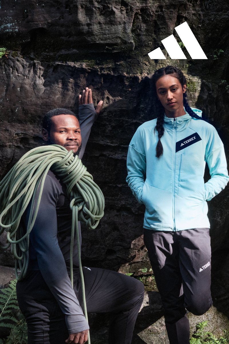 To klatrere: en mann i en tettsittende svart langermet skjorte med grønn klatresnor, og en kvinne i en lyseblå zip-up jakke og svarte bukser.
