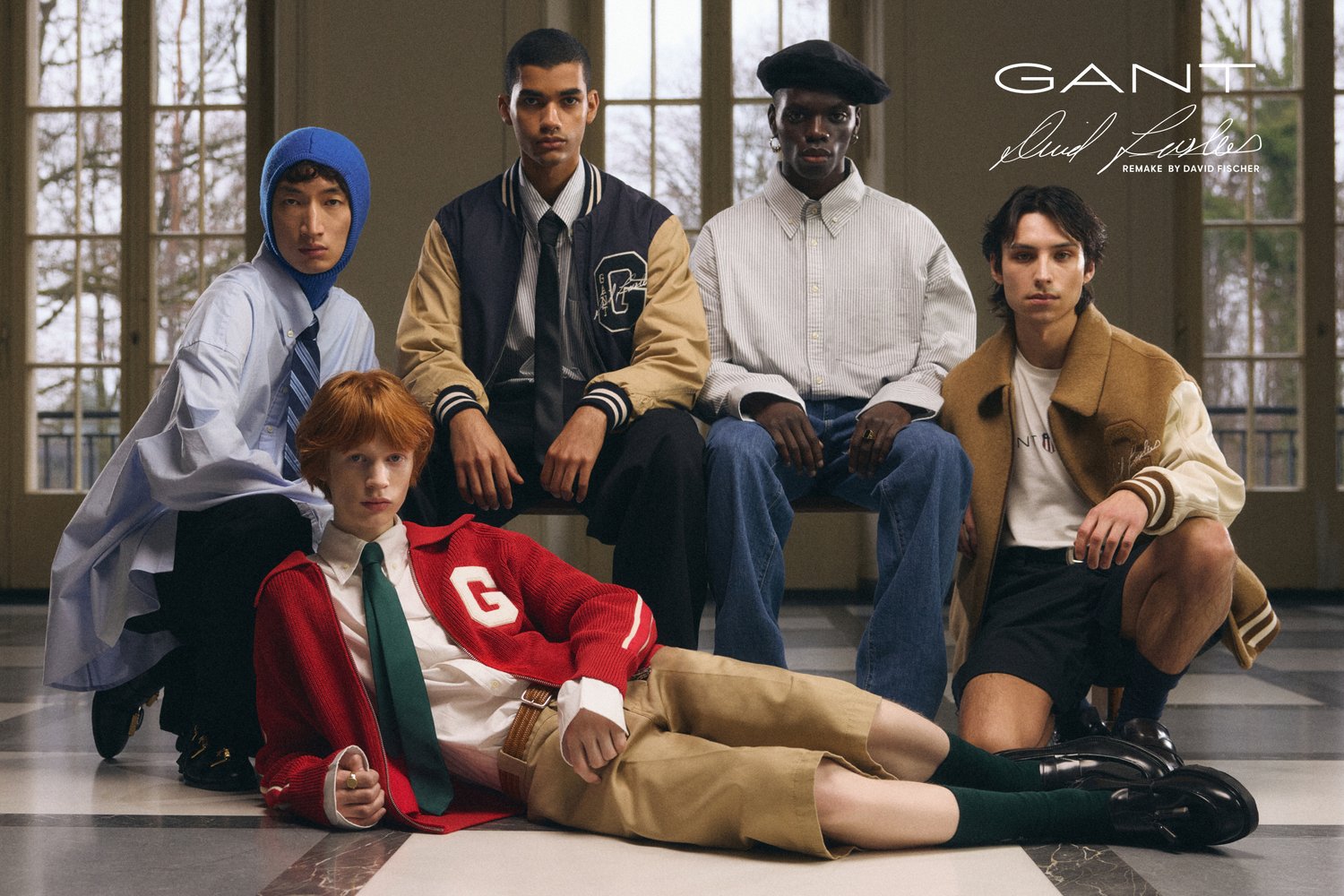 Fem modeller poserar i ett svagt upplyst rum och visar upp olika modes styles. I förgrunden finns en sittande modell i en röd cardigan och khakishorts.