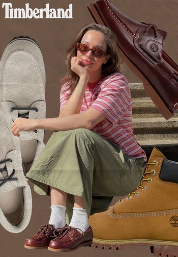 Woman in sunglasses and casual clothes sitting, surrounded by Timberland shoes: beige loafers, brown boots, and burgundy moccasins.