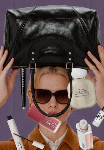 Black leather handbag with two top handles, glossy finish. Surrounding beauty products include a mascara, lip color, and hair perfume.