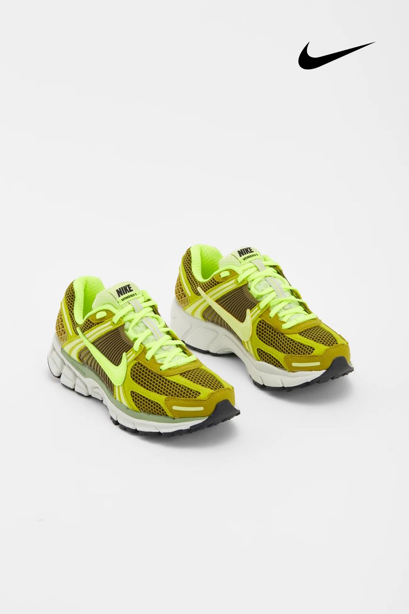 Neon gele en olijfgroene Nike hardloopschoenen met een bovenwerk van mesh en een witte zool, tentoongesteld op een effen achtergrond.