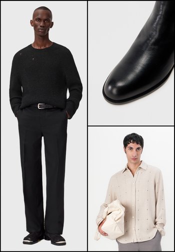 Pull en laine noir avec un léger effet usé, pantalon noir ajusté et bottines en cuir noir lisse. Chemise boutonnée beige clair avec des pois.