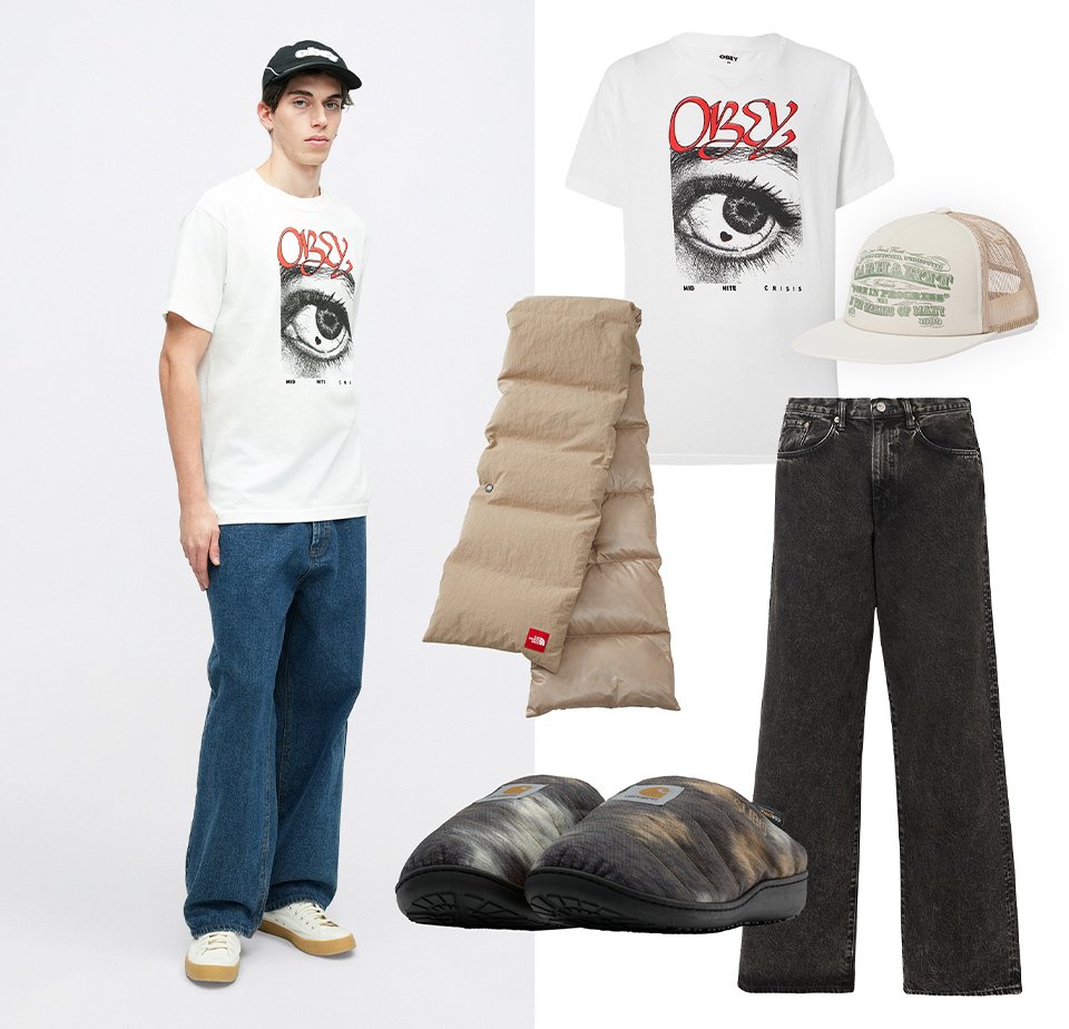 T-shirt graphique blanc avec impression d'œil, doudoune beige, jean noir à jambes larges, chaussons gris et noirs, et casquette beige en mesh avec texte vert.