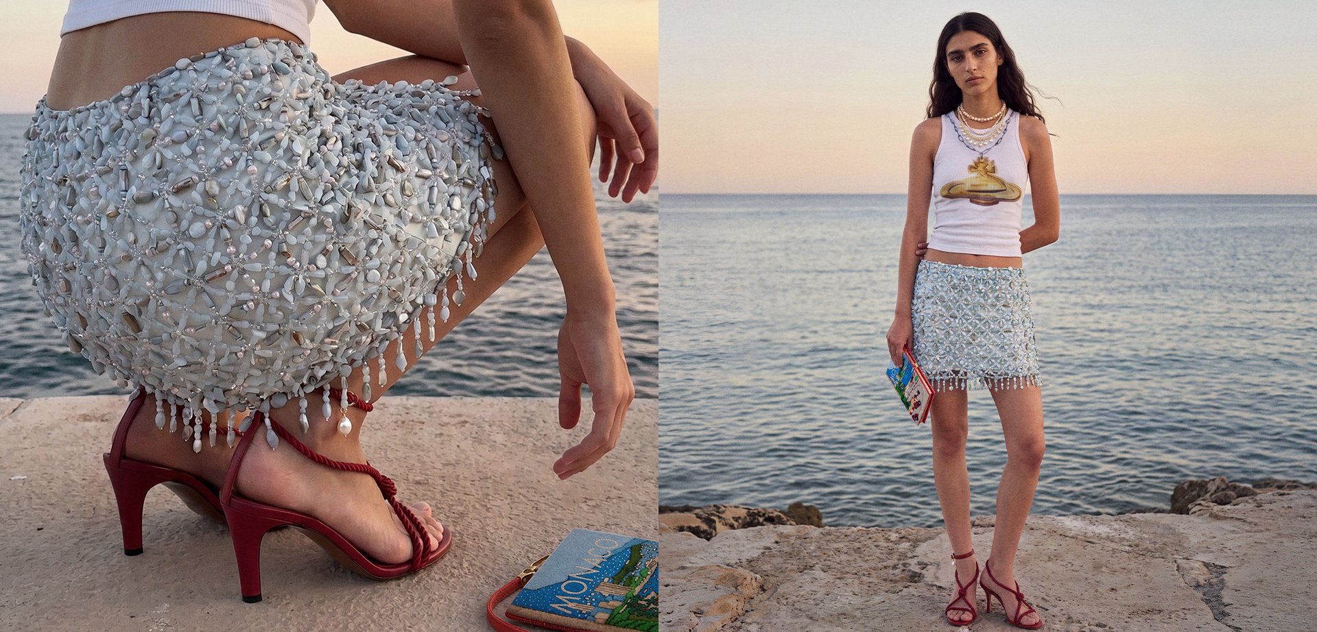 Frau am Meer, die einen weißen, mit Perlen besetzten Rock, ein grafisches Tanktop und rote High-Heel-Sandalen trägt und eine bunte Clutch hält.