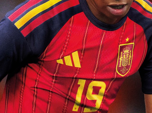 Fußballspieler trägt Spaniens rot-gelbes Trikot mit der Nummer 19, Adidas-Logo und Mannschaftswappen mit einem Stern.