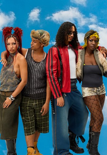 Groupe de quatre individus stylés posant contre un ciel bleu avec des nuages, mettant en valeur une mode vibrante, des coiffures uniques et des expressions confiantes.