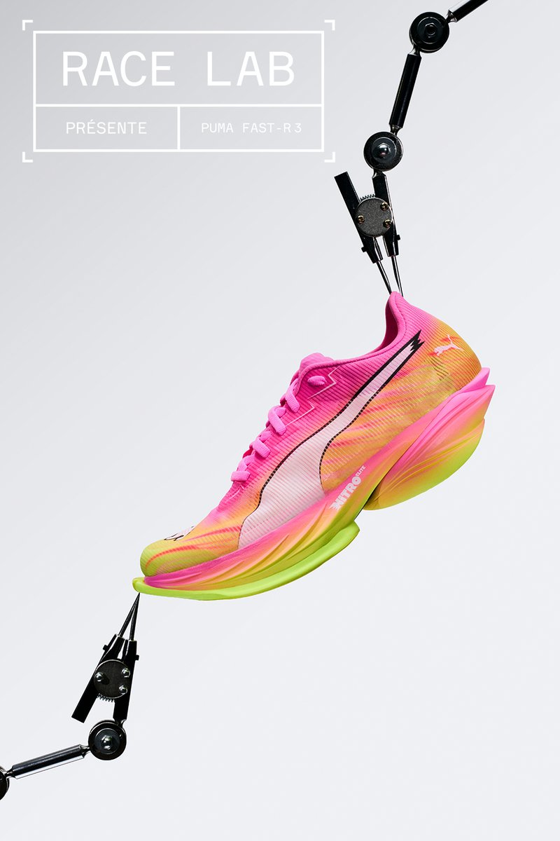 Pink-gelber Puma FAST-R3 Laufschuh, gehalten von Roboterarmen vor schlichtem hellem Hintergrund, mit dem Text "RACE LAB" darüber.