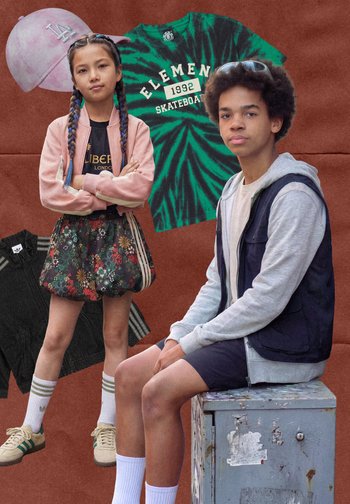 Fille aux cheveux tressés portant une jupe à fleurs et une veste rose, les bras croisés ; garçon en sweat à capuche, gilet et short assis sur une boîte métallique.