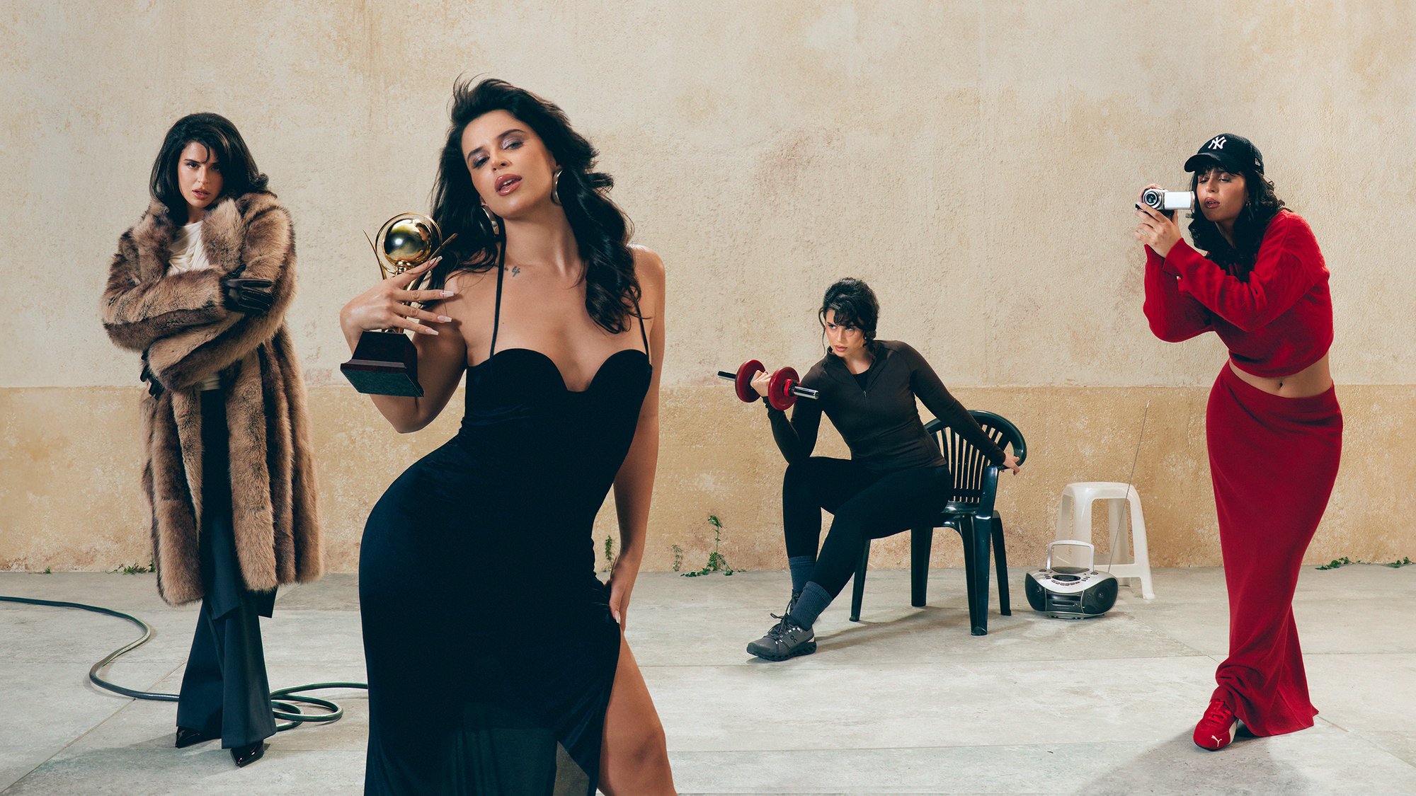 Cuatro mujeres en un entorno minimalista: una posa con un trofeo, otra levanta pesas, y las otras dos interactúan con una cámara, mostrando estilos diversos.