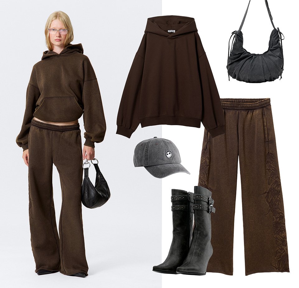 Bruine hoodie en bijpassende broek met elastische tailleband. Accessoires zijn een zwarte tas, een grijze pet en zwarte haklaarzen.