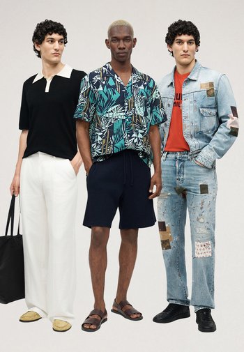Trois hommes posent vêtus de tenues décontractées : pantalon blanc avec polo noir, chemise à imprimé tropical avec short bleu marine et veste en jean patchée avec jean.