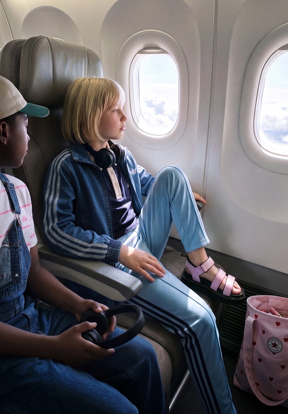 Zwei Kinder sitzen nebeneinander in einem Flugzeug, eines schaut aus dem Fenster, das andere hält Kopfhörer im Schoß.