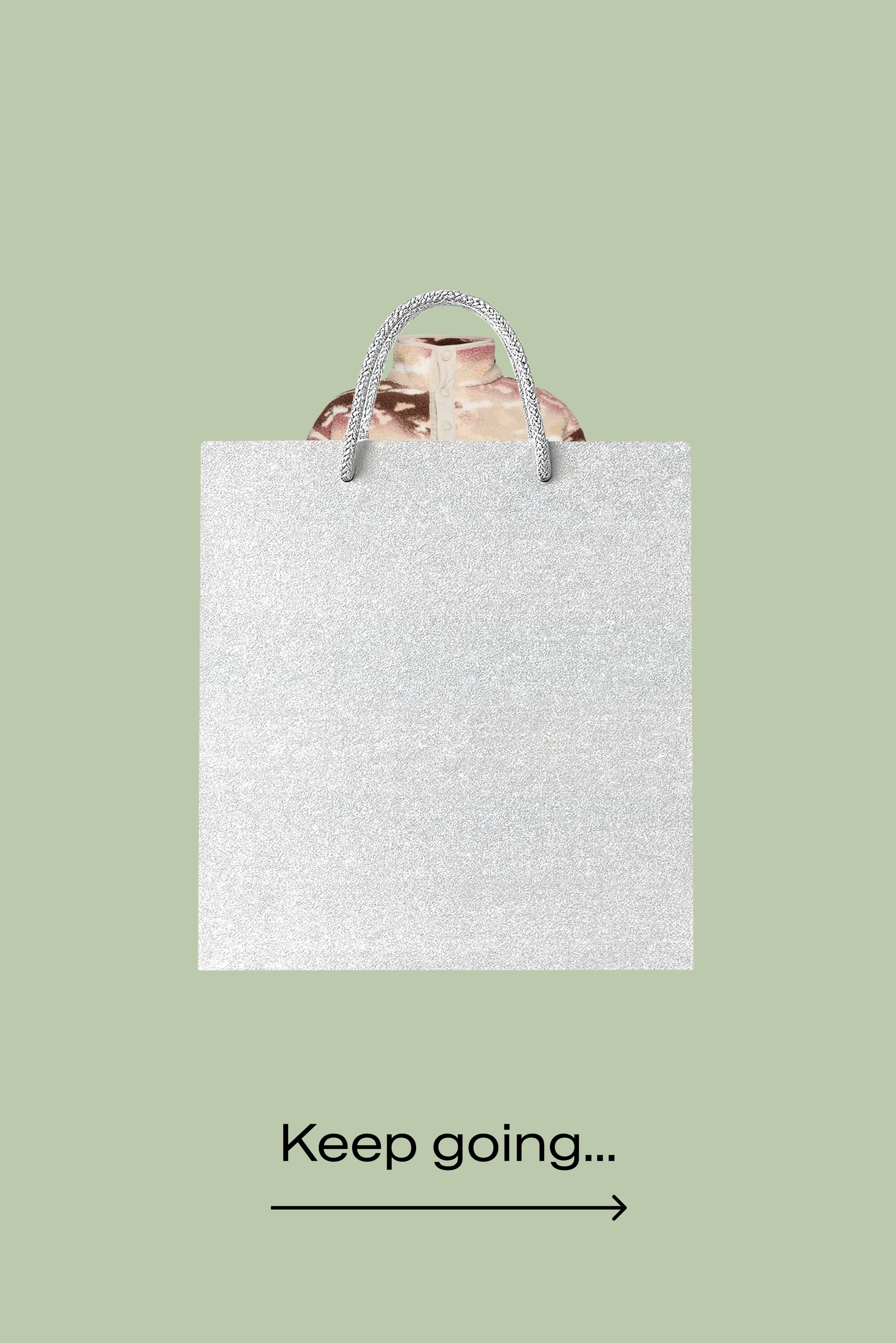 Borsa da shopping in carta glitter argento con superficie testurizzata e manici a corda intrecciata, contenente una maglietta con motivo parzialmente visibile sopra la borsa.