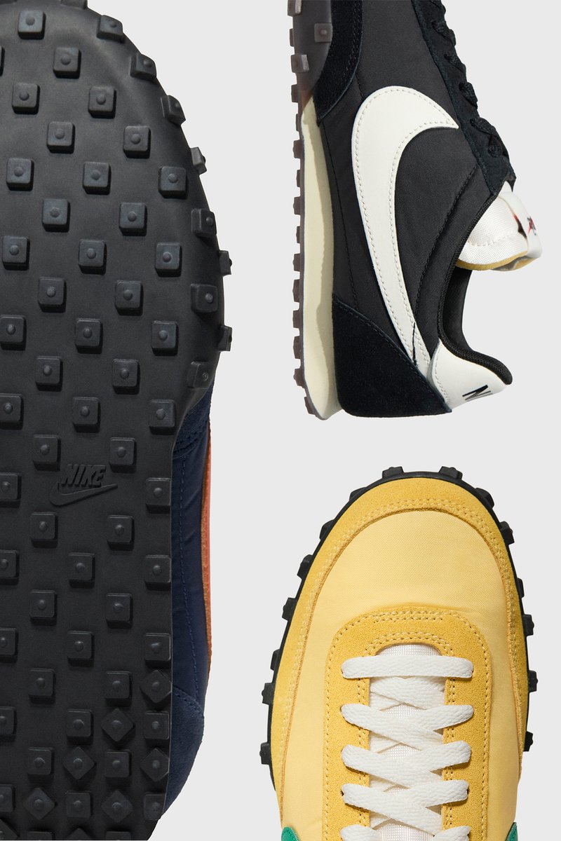 Nike-schoenen met een zwart en marineblauw bovenwerk met witte accenten, een gestructureerde gele stof en een robuuste zwarte buitenzool met verhoogde noppen.