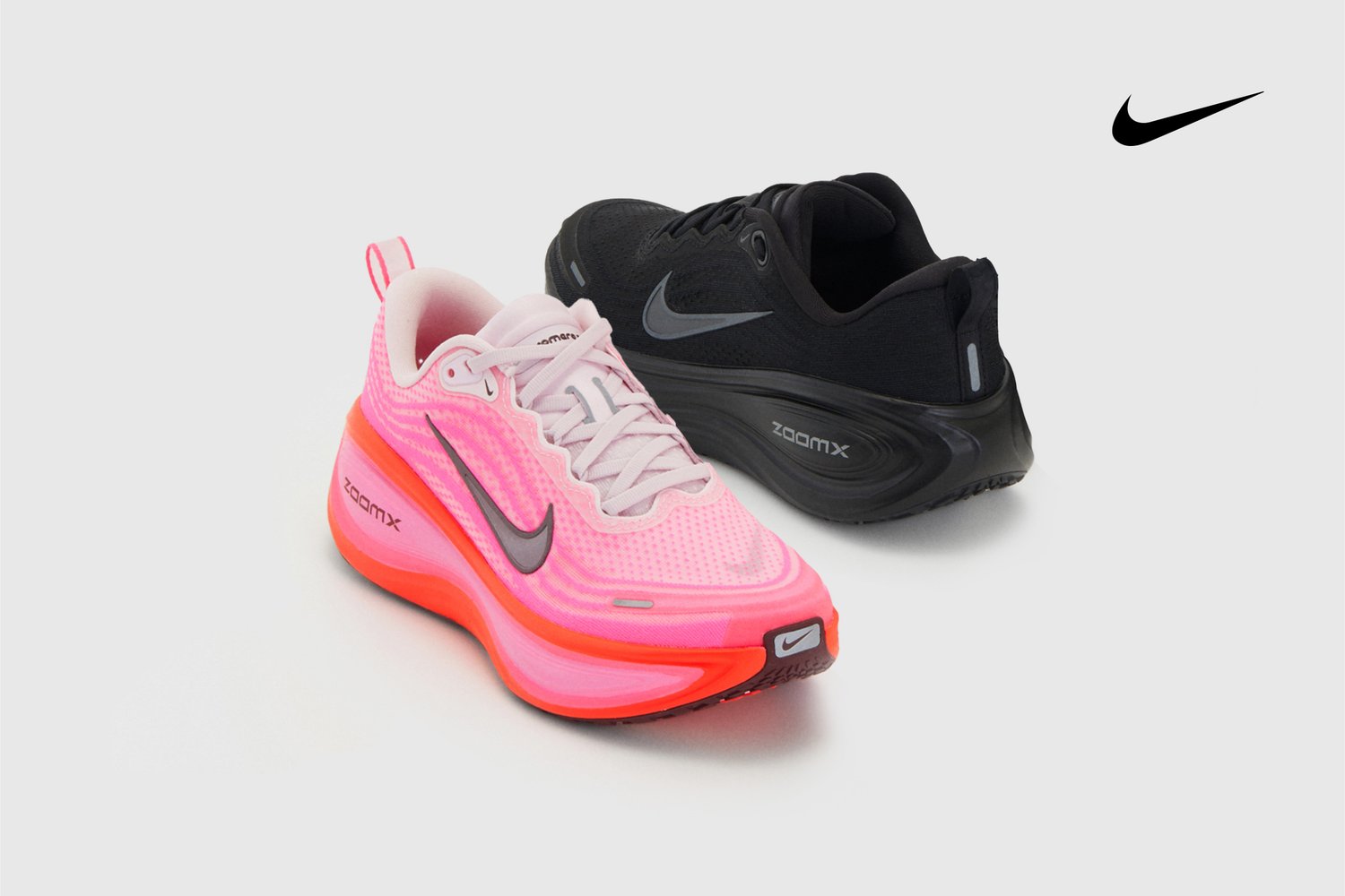 Nike ZoomX hardloopschoenen in roze en zwart. Roze schoenen hebben een gestructureerde bovenkant en een heldere zool; zwarte schoenen hebben een gladde afwerking en een slank design.