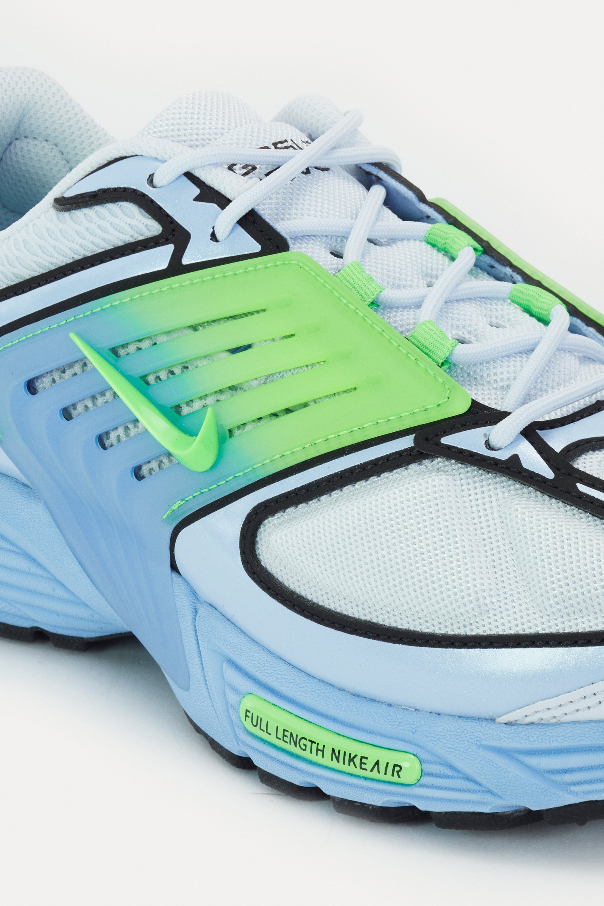 Lichtblauwe sportschoen met groene accenten en een zwarte zool, met een opvallend Nike-logo en het label "FULL LENGTH NIKE AIR".