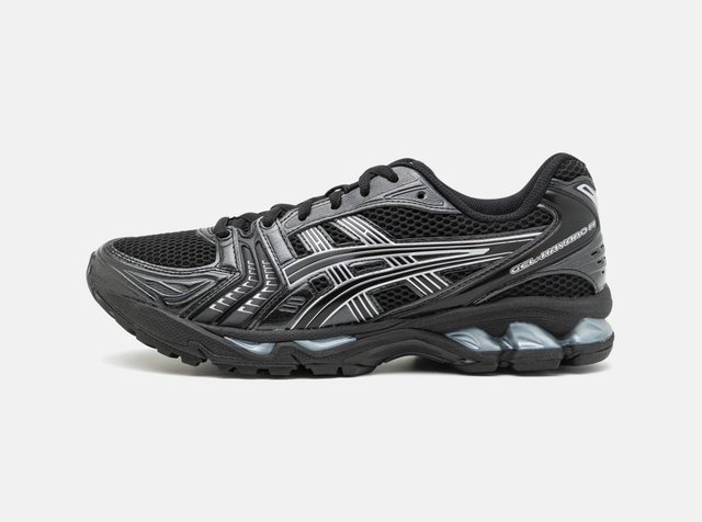 Ténis desportivo preto e cinzento com tecido em rede, sobreposições sintéticas, sola acolchoada e fecho com atacadores, visto de lado.
