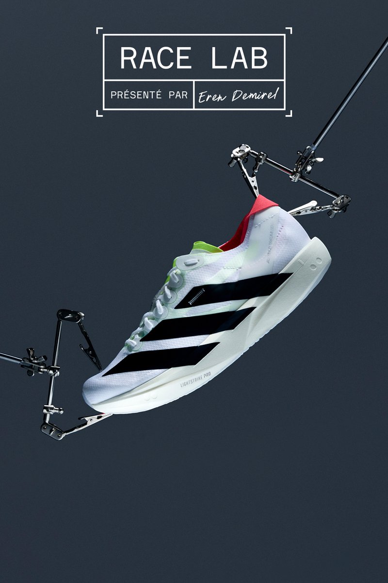 Baskets de course blanches avec des rayures noires, des accents verts et un talon rouge. Design aérodynamique avec une tige texturée, semelle légère marquée "LIGHTSTRIKE PRO."