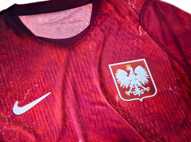 Rotes Sporttrikot mit weißem Nike-Logo auf der linken Seite und weißem gekrönten Adler-Emblem auf der rechten Brust.