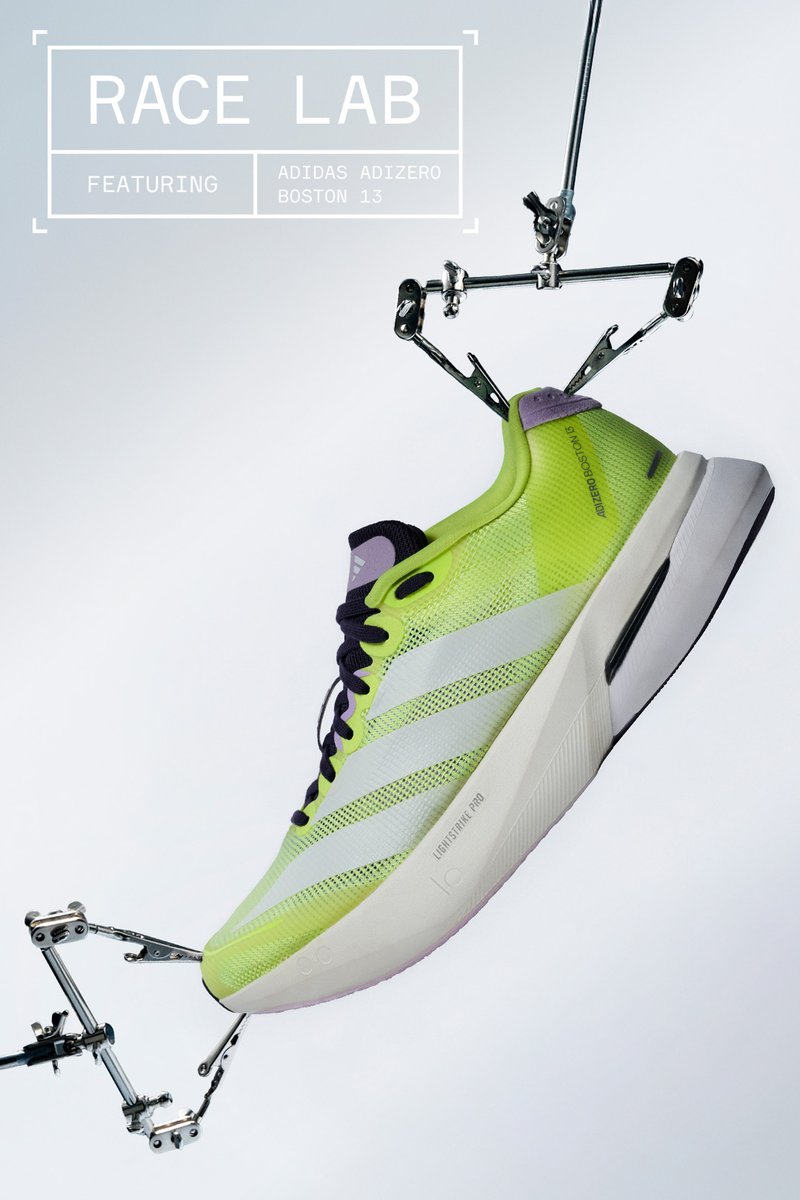 Bright yellow Adidas Adizero Boston 13 running shoe held by metal clamps against a plain light background.