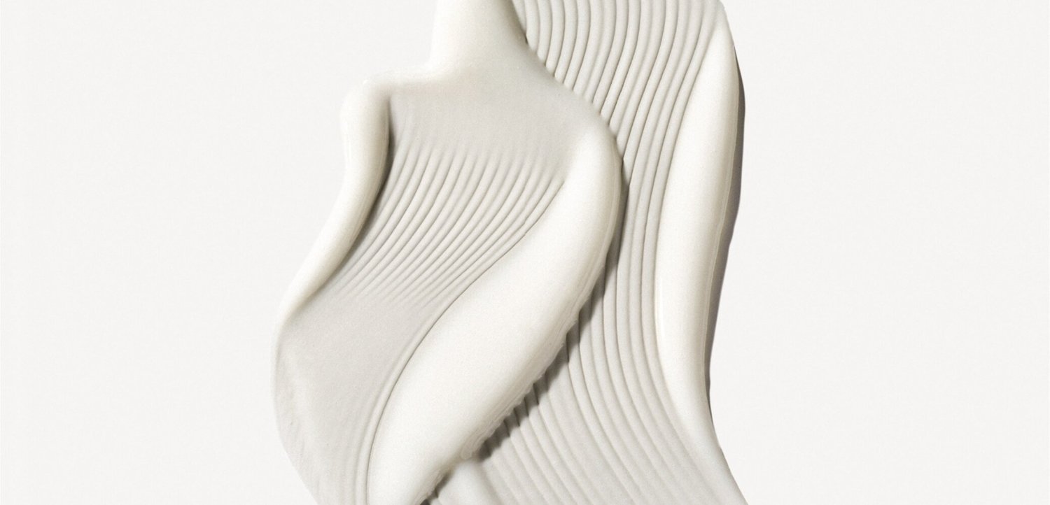 Two modern, white sculptural chairs with high backs and vertical grooves, placed side by side on a plain background.