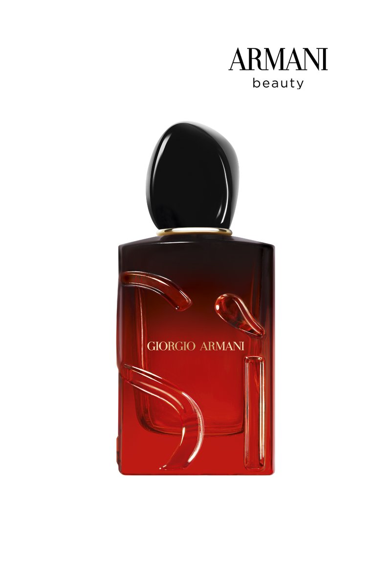 Red perfume bottle with a rounded black cap, featuring clear, artistic lettering and design elements. Brand name "Armani" visible at the top.