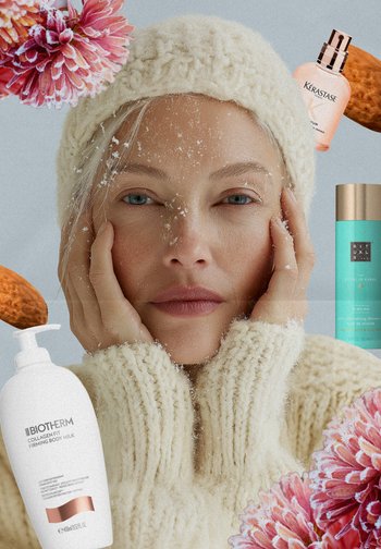 White knitted sweater with thick texture, snowy accents on face, and floral elements. Surrounding beauty products include a cream and oil in colorful packaging.