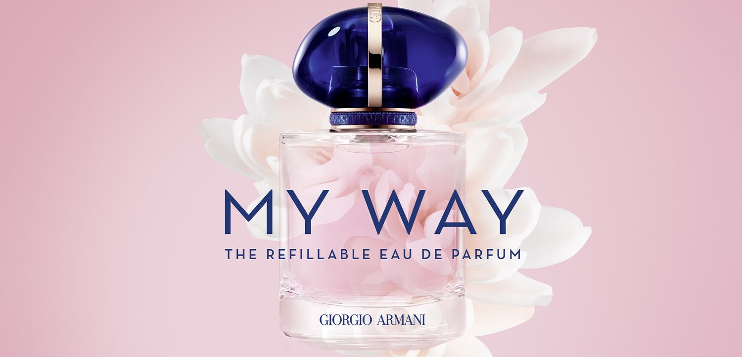 Parfume flaske med mørkeblå hætte mærket "MY WAY" genopfyldelig eau de parfum af Giorgio Armani mod en blød lyserød blomsterbaggrund.
