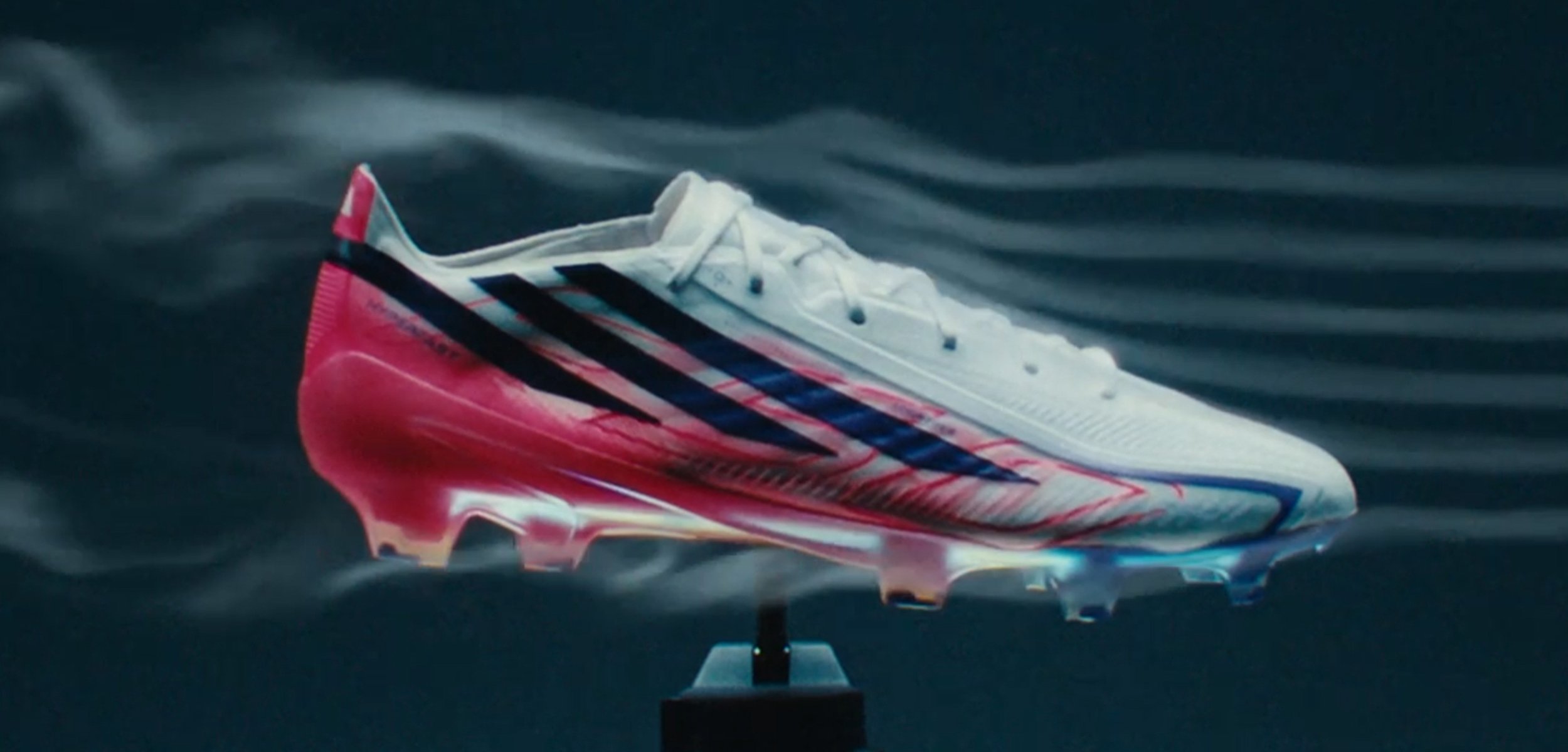 Chaussure de football blanche et rouge avec des bandes noires montrée dans une simulation d’écoulement d’air avec des courants d’air visibles pour des tests aérodynamiques.