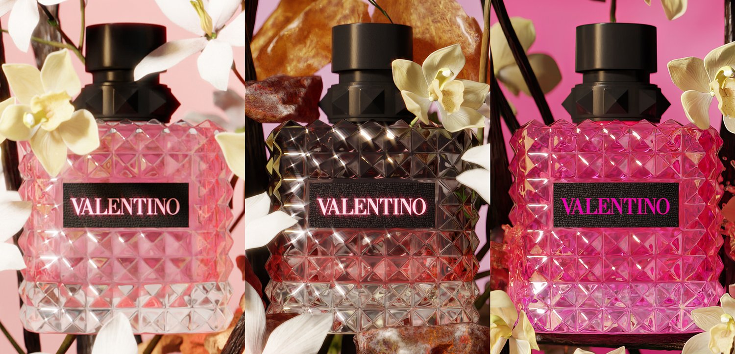 Three faceted Valentino perfume bottles in pink and purple tones surrounded by white and yellow orchids against a pink background.