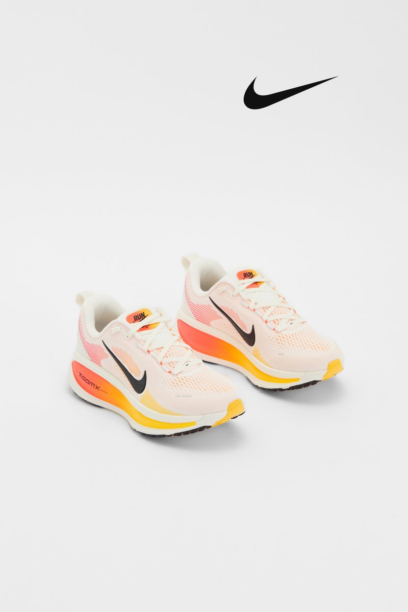 Lightweight Nike running shoes displayed with pink, orange, and yellow accents against a white background. Features a prominent black logo.