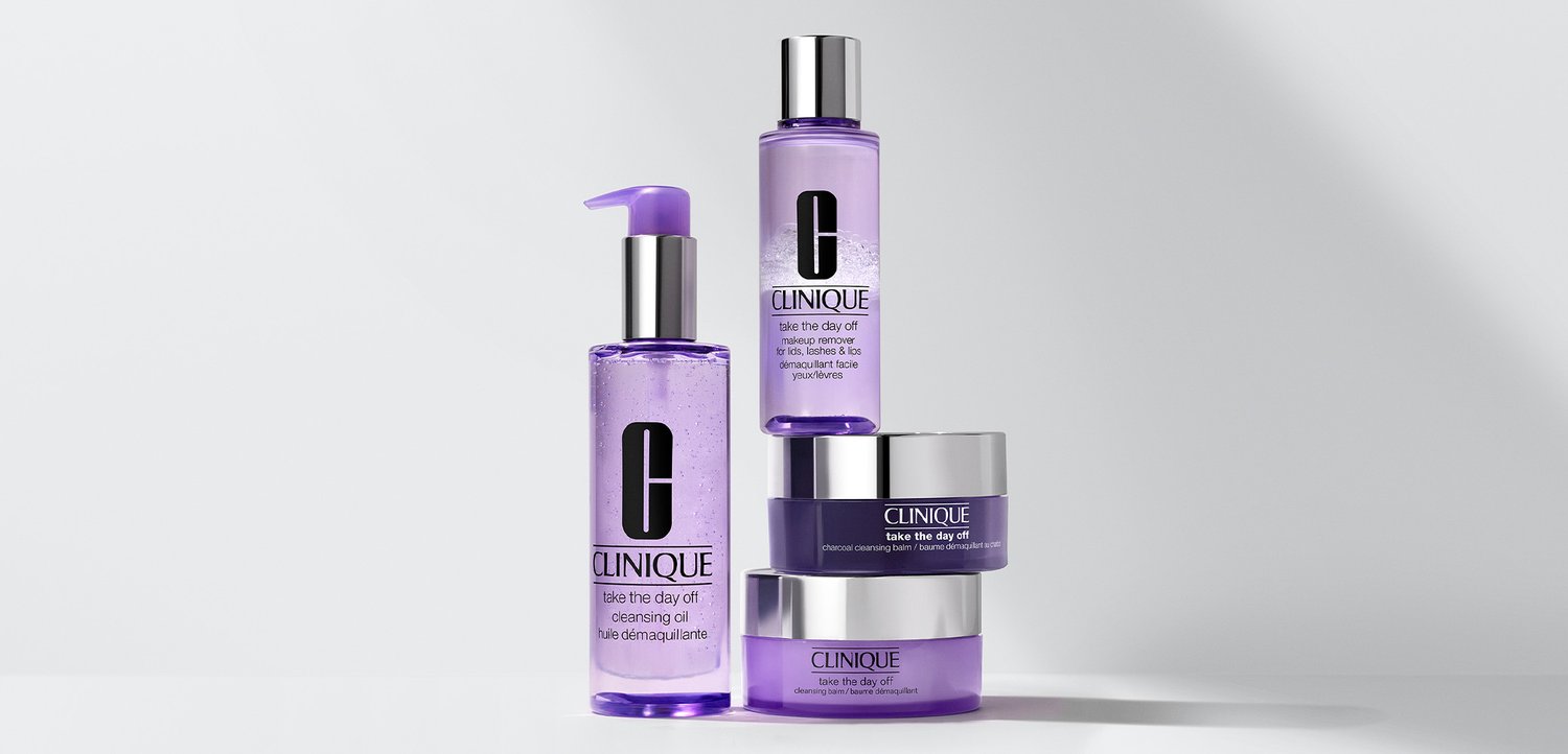 Vier Clinique Hautpflegeprodukte mit einem lilafarbenen Farbschema. Enthält ein Reinigungsöl mit Pumpspender, zwei Dosen und eine kleine Flasche mit einer Tülle.