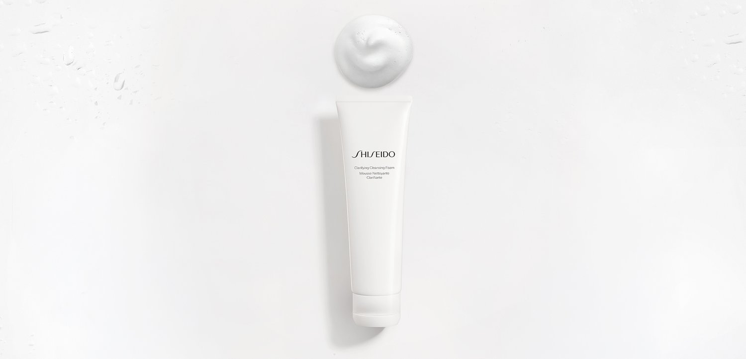 Weisse Tube Shiseido Reinigungsschaum mit einem Klecks Schaum darüber vor einfachem weissem Hintergrund.