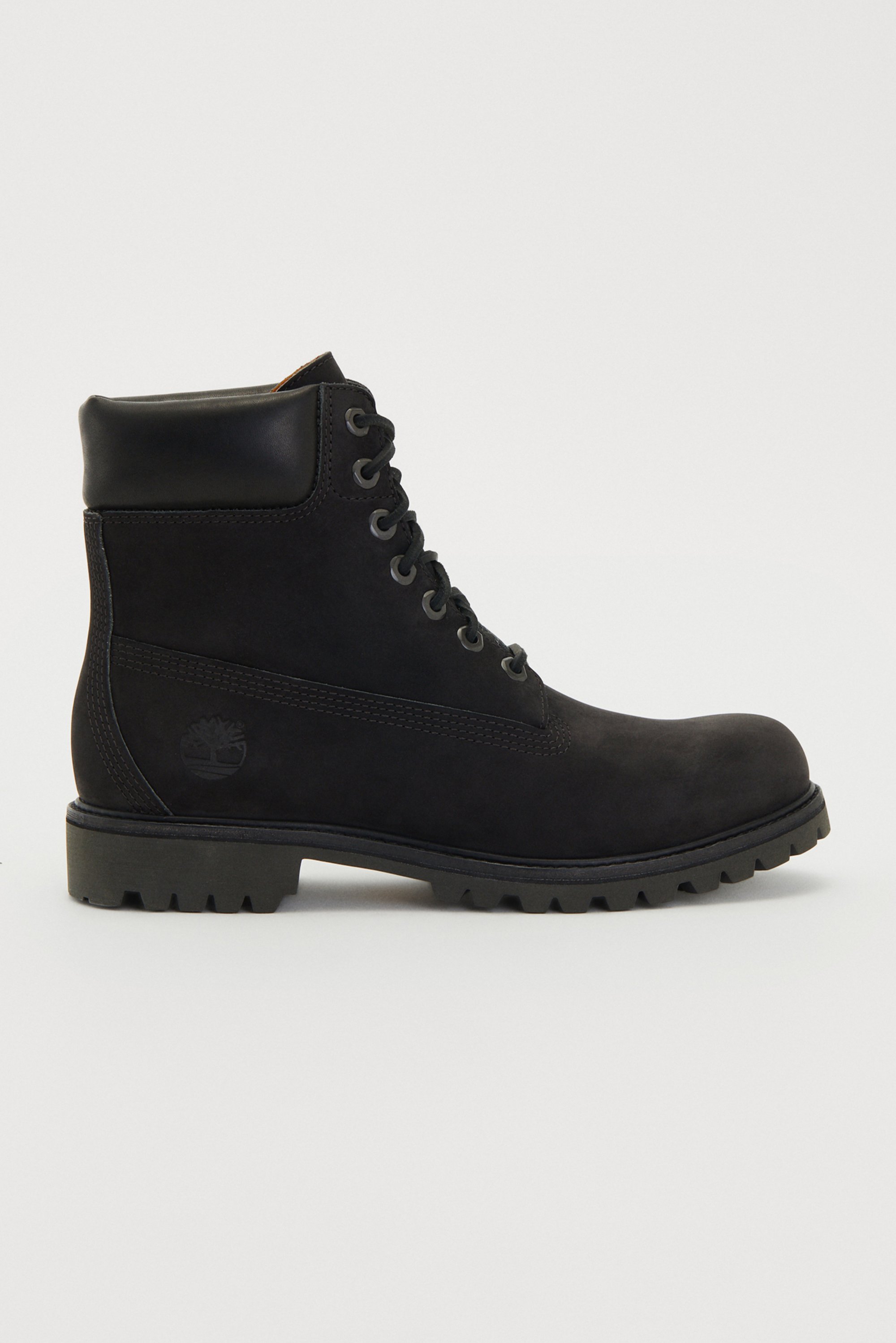 Black suede ankle boots featuring a leather collar, six metal eyelets, and a rubber lug sole. They include a logo on the side and textured paneling.