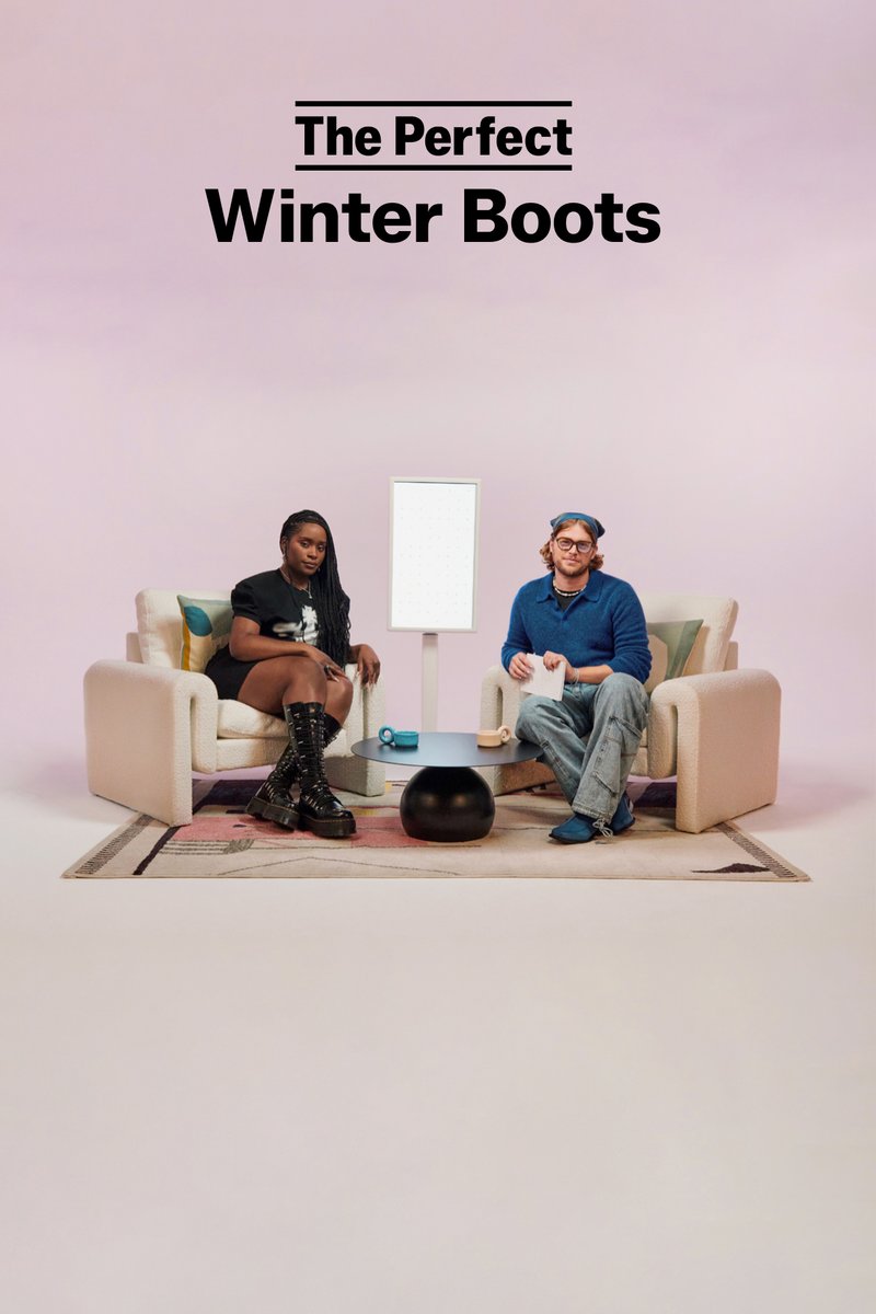 Twee personen zitten op moderne stoelen voor een minimalistische tafel. Een levendige kleed ligt onder hen, en een lichtarmatuur staat in de buurt.