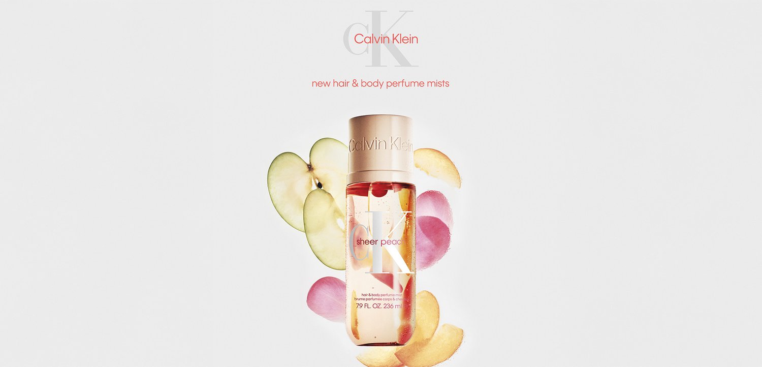 Flacon de brume parfumée Calvin Klein Sheer Peace entouré de pétales de pomme, de pêche et de rose sur fond blanc.
