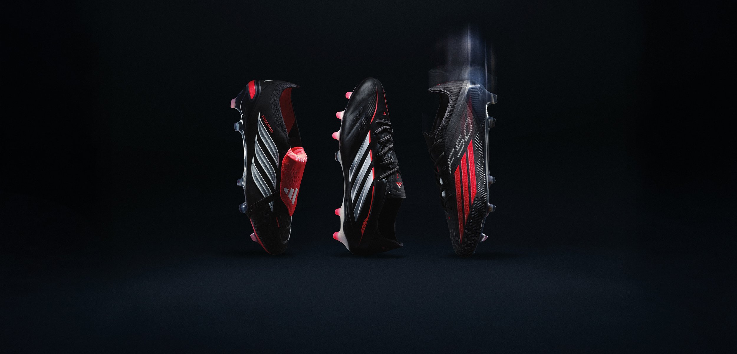 Drie zwart-rode voetbalschoenen weergegeven vanuit de achterkant, zijkant en bovenaanzicht tegen een donkere achtergrond.