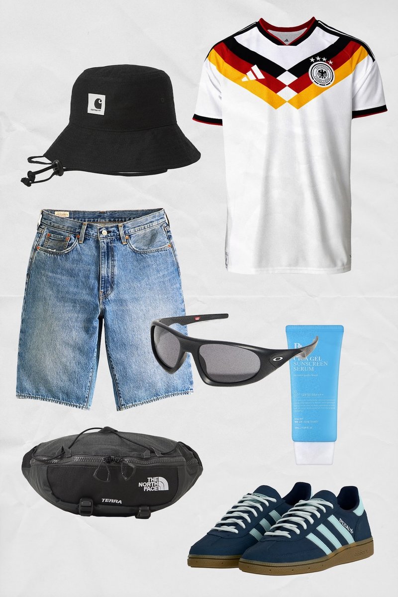 Schwarzer Fischerhut, deutsches Fußballtrikot, Jeansshorts, schwarze Sonnenbrille, Tube Sonnencreme, schwarze Bauchtasche und blaue Adidas-Sneaker.