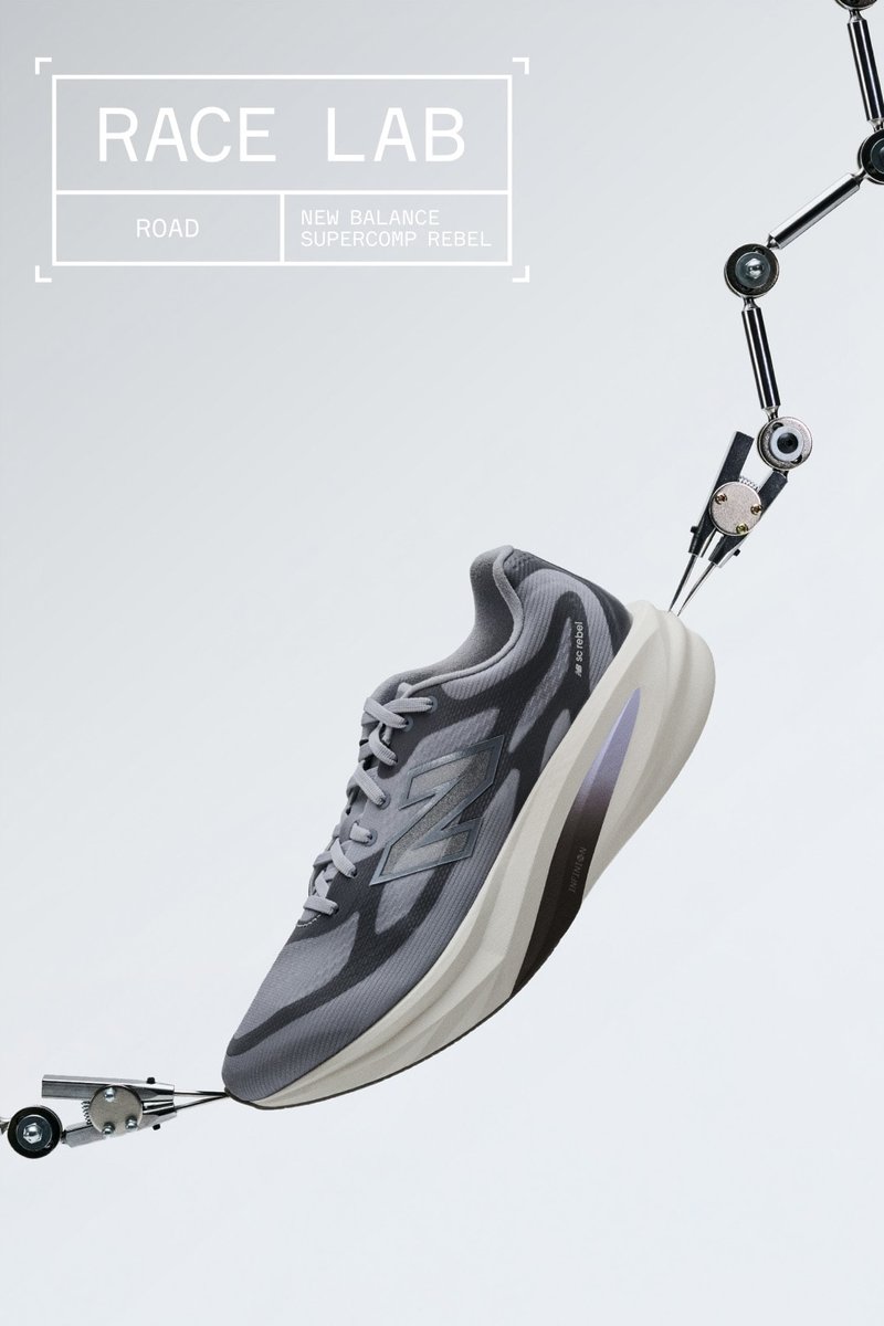 Gray New Balance Supercomp Rebel running shoe held by robotic arms on a light gray background with Race Lab text.