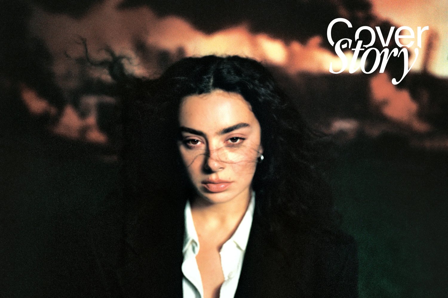 A woman with dark, curly hair gazes intensely at the camera against a dramatic, smoky background. The text "Cover Story" appears at the top.