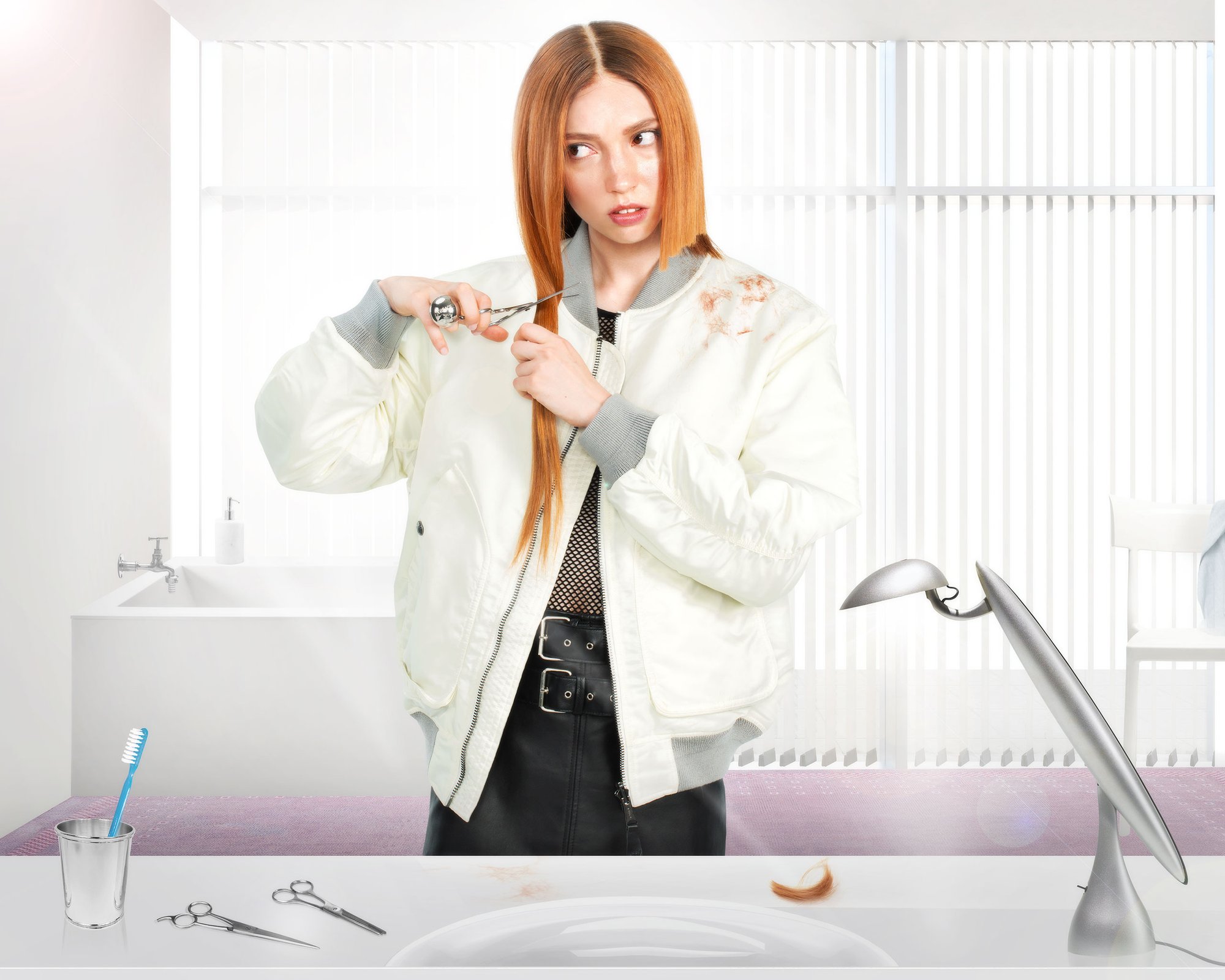 A woman with long hair cuts a section while standing at a table, with scissors, a toothbrush in a cup, and a lamp nearby.