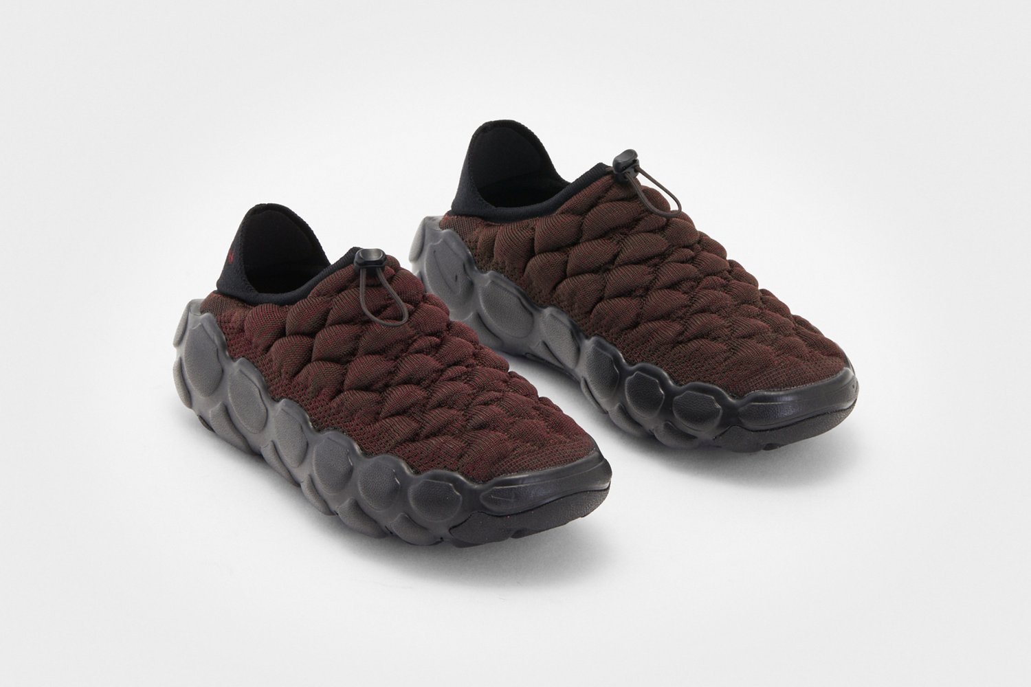 Zapatillas burdeos sin cordones con un upper texturizado y tejido, y una suela de goma negra, que cuentan con pestañas de tracción ajustables en el talón.