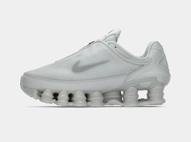 Zapatilla Nike gris claro con suela segmentada acolchada y sutil logo swoosh en el lateral, vista desde el lado exterior.