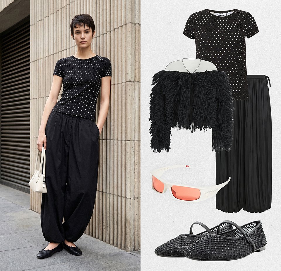 Vrouw draagt zwart polkadot t-shirt en losse zwarte broek, houdt witte handtas vast; getoonde bijpassende outfit met jas, zonnebril en schoenen.