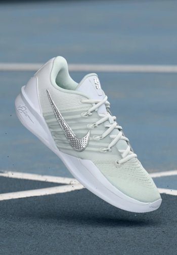 Chaussure de sport vert clair avec une tige texturée, des accents blancs et un swoosh Nike argenté brillant. Dotée d'une semelle coussinée et de lacets.