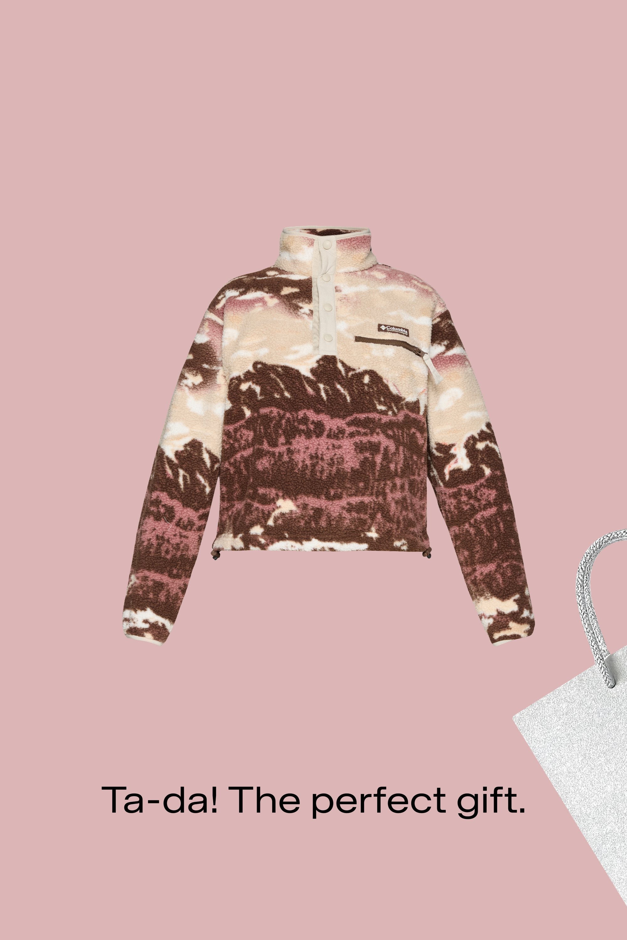 Pullover in pile marrone, rosa e crema con motivo a montagne, zip a metà e tasca frontale. Borsa regalo argentata a lato.