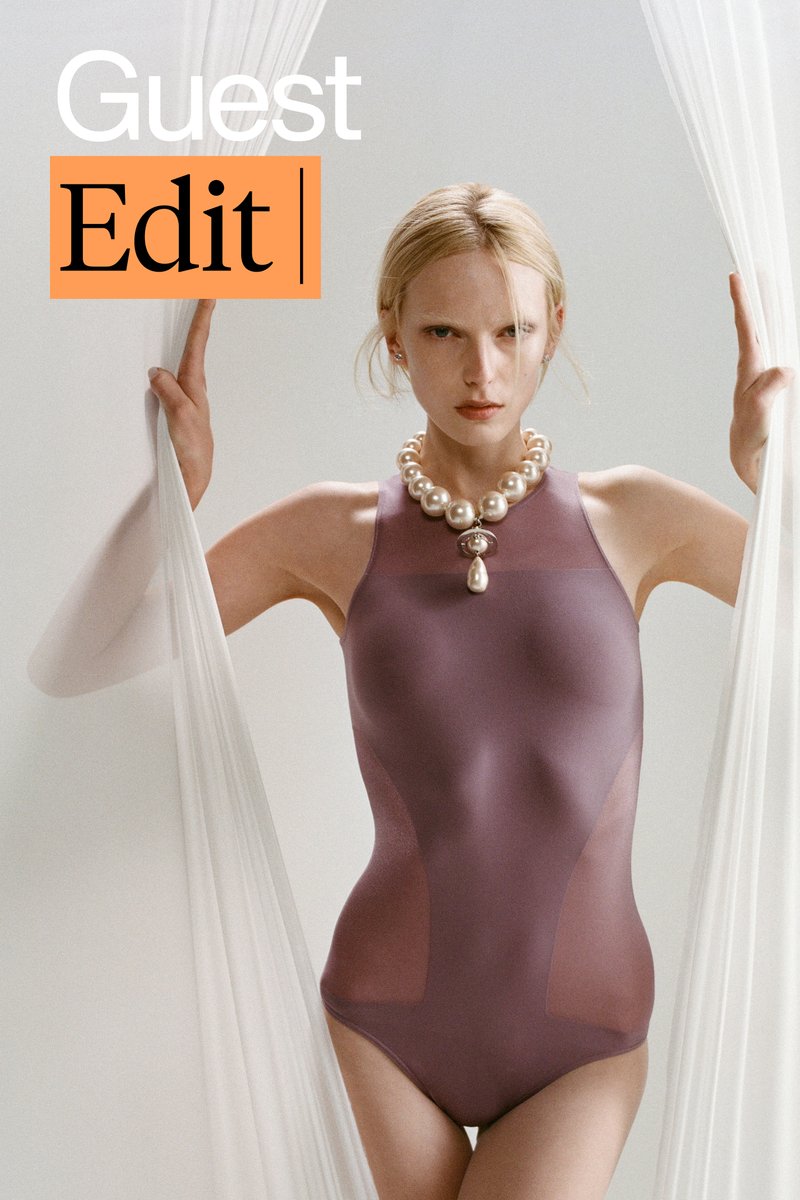 Modelo en un body morado ajustado y collar de perlas posa entre telas blancas transparentes, transmitiendo una estética de moda sofisticada.