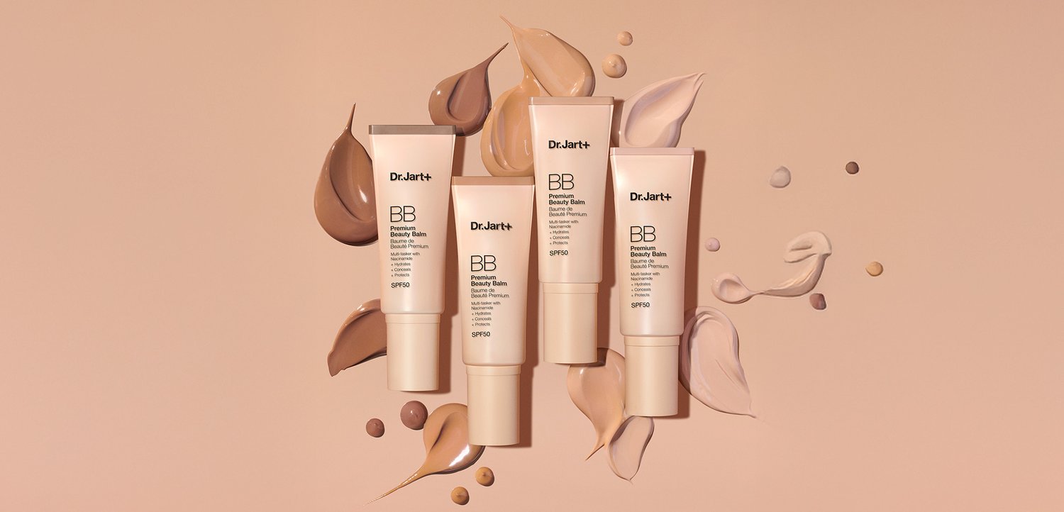 Vier Dr. Jart+ BB-Creme-Tuben in verschiedenen Beige- und Brauntönen mit einem glatten, matten Finish, daneben Proben der Creme auf hellem Hintergrund.