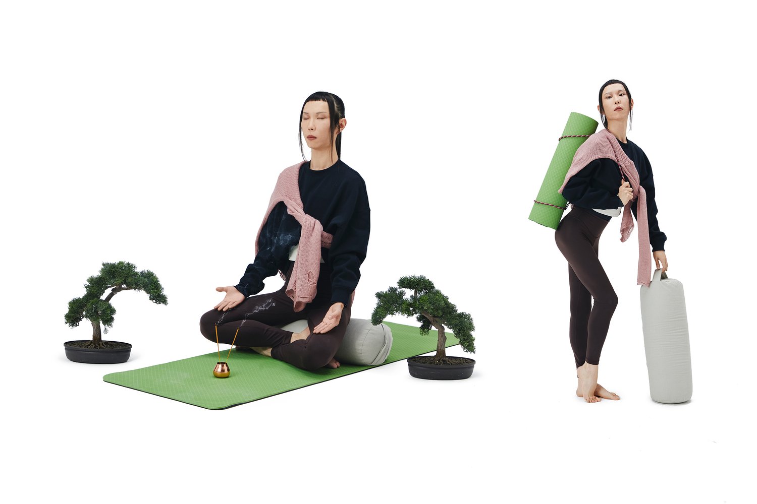 A woman sits in meditation on a green yoga mat beside a bonsai tree, while standing with a yoga mat and bolster in hand, wearing activewear.